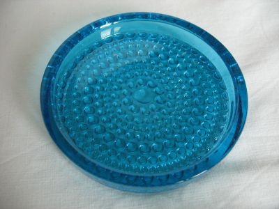 Cascade coaster/ashtray
Produced by Wood Brothers Glass Co and marketed under the range name Cascade. The original design was by Oiva Toikka in 1964 for Nuutajarvi Notsjo of Finland, pattern name 'Kastehelmi' (dew drop). Production of the Kastehelmi pattern was later continued at Iittala. It is assumed Wood Bros therefore made these items under licence.
Keywords: sold;pressed;ash;barware