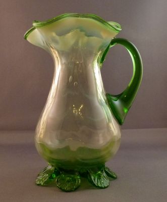 Opalescent drape and rib creamer/milk jug
Uranium cased body with green uranium handle and shell crimped feet. Sharp pontil mark. British?
Keywords: table;blown;british